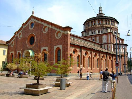 a large brick building with a clock tower in front of it at Appartamento San Michele in Milan