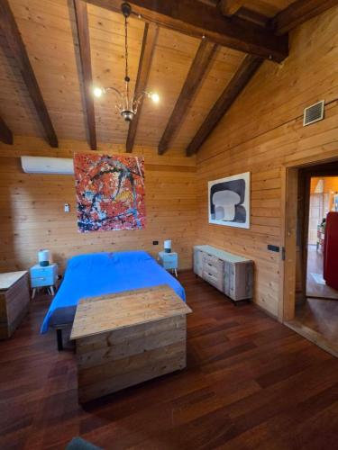 a bedroom with a blue bed and wooden walls at La Baita di Lusso Bagnone in Bagnone