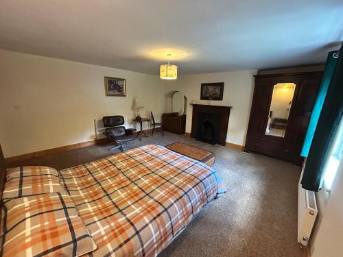 a bedroom with a bed and a fireplace at Herberts Cottage in Wormegay