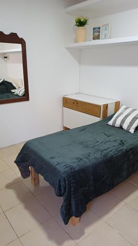 a bed in a room with a mirror and a table at Departamento Salomé in Eduardo Castex