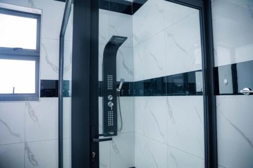 a shower in a bathroom with a glass door at Oasis Apartment Suites in Ezulwini