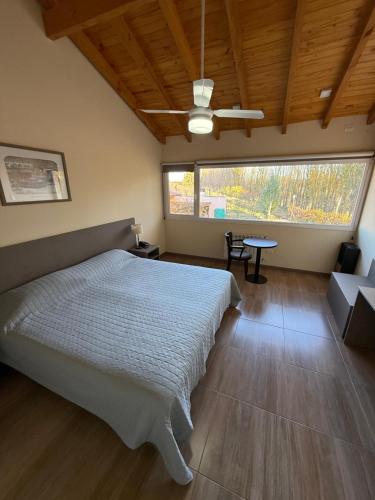 a bedroom with a bed and a table in it at Los Nogales de Tatash in Centenario