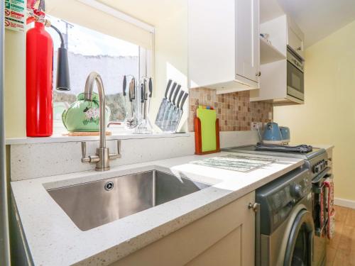 a kitchen with a sink and a stove at Lightkeepers Fold in Eyemouth