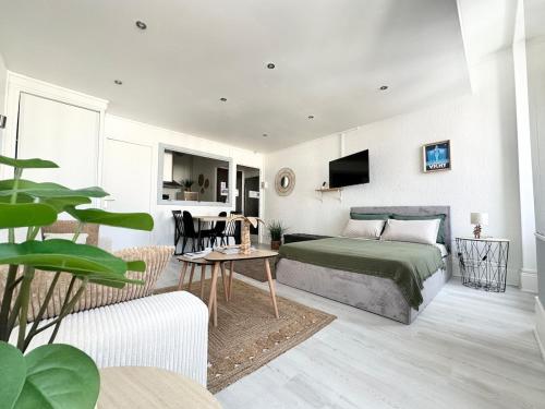 a bedroom with a bed and a living room at Appartement Standing proche des Thermes in Vichy