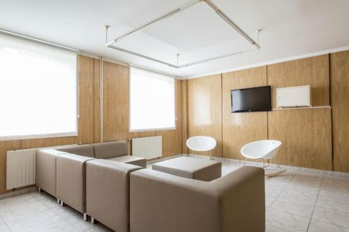 a waiting room with couches and a flat screen tv at Residencia Universitaria Resa Siglo XXI in Culleredo