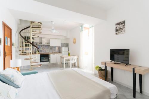 a white bedroom with a bed and a living room at Mimì sul Mare in Massa Lubrense