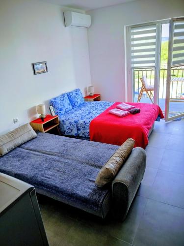 a bedroom with two beds and a red blanket at Apartman DimDam in Veliko Gradište