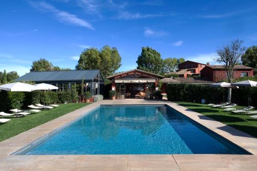 a swimming pool in the backyard of a house at Locanda Rossa in Capalbio