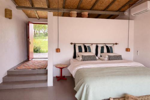 a bedroom with a large bed and a window at Monte da Palmeira in Vila Nova da Baronia