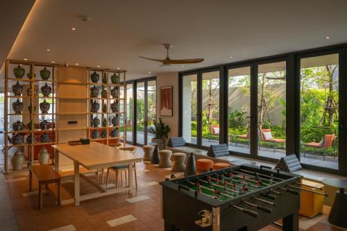 a living room with a table and a foos ball at PAAK Hotel Suvarnabhumi in Lat Krabang