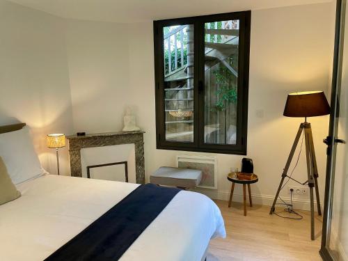 a bedroom with a bed and a window at Suite indépendante avec jardin, 2 chambres communicantes, hyper centre Arcachon in Arcachon