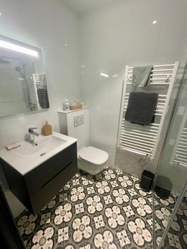 a bathroom with a sink and a toilet and a mirror at Suite indépendante avec jardin, 2 chambres communicantes, hyper centre Arcachon in Arcachon