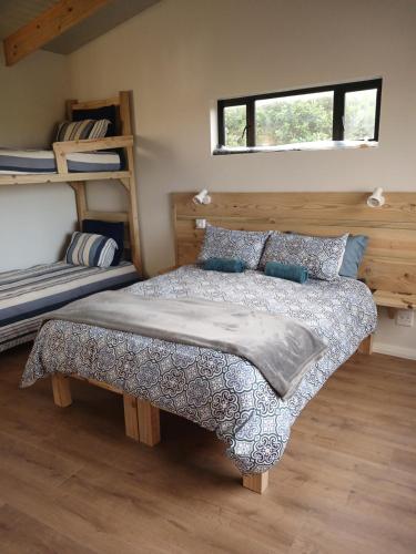 a bedroom with a bed and two bunk beds at Seals Tides - sleeps 12 in Cape St Francis
