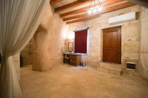 a large room with a wooden door in a building at Helike Cave Suites in Uçhisar