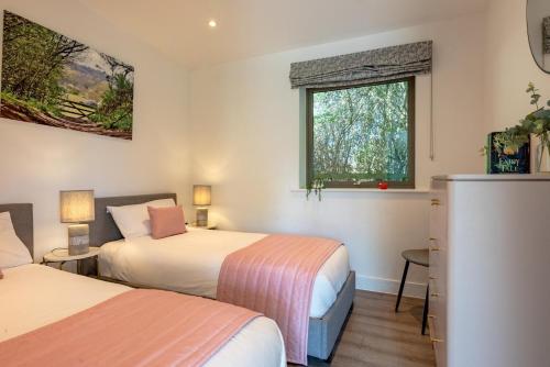 a bedroom with two beds and a window at 2 Bed in Colchester oc-82397 in East Bergholt