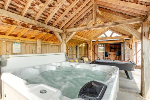 a hot tub in a barn with a pool table at 5 Bed in Tiverton oc-48151 in Cadeleigh
