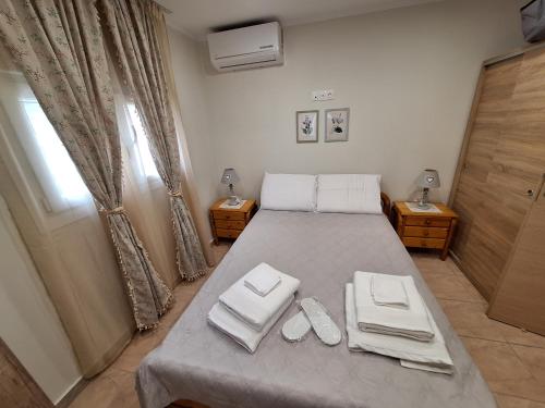 a bedroom with a bed with two white slippers on it at Chios Flower House in Agia Ermioni