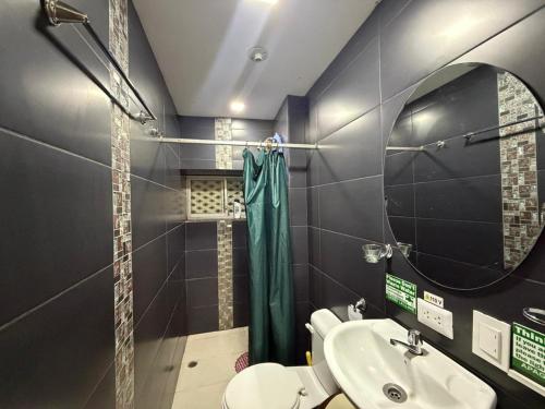 a bathroom with a sink and a mirror and a toilet at Hostal Atlantis Middle World in Quito