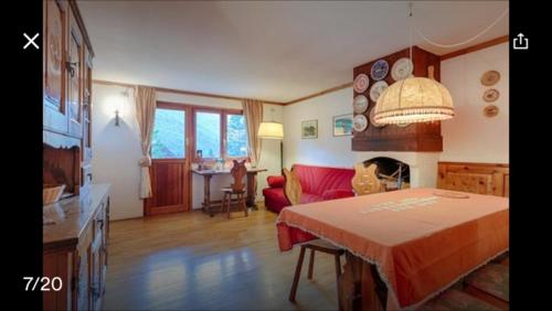 a living room with a red couch and a table at Appartamento Borealis in Cogne