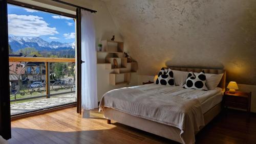 a bedroom with a bed and a large sliding glass door at To Tu in Czarna Góra