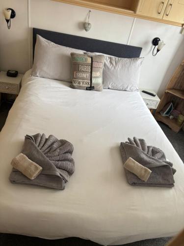 a bed with two mitts and towels on it at 11 Oaklands in Porchfield