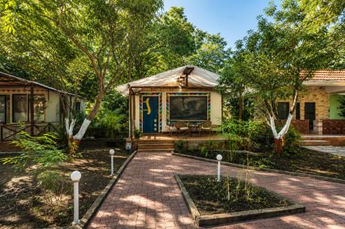 a house with a pavilion in the middle of a garden at The Wilds Villa Gir Jungle Stay with Swimming Pool in Sasan Gir