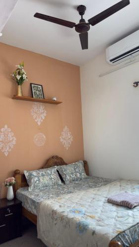 a bedroom with a bed and a ceiling fan at Trayi stay in Mysore