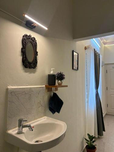 a bathroom with a sink and a mirror on the wall at Trayi stay in Mysore