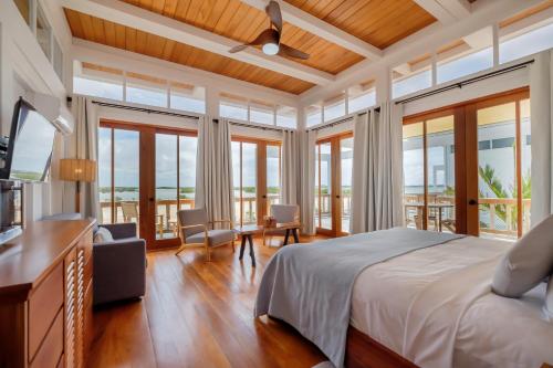 a bedroom with a large bed and windows at Aruna Resort & Villas in San Pedro