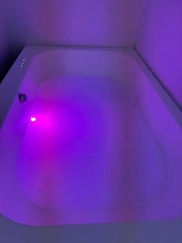 a purple bath tub with a pink light in it at Z&N Apartment in Levico Terme