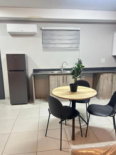 a kitchen with a table and chairs with a potted plant at Elisa's Haven in Matsulu