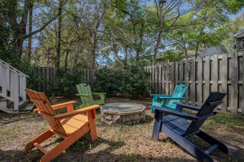 three chairs and a fire pit in a backyard at Chateau Relaxo by Oak Island Accommodations in Oak Island