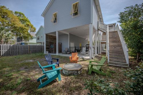 a group of chairs sitting outside of a house at Chateau Relaxo by Oak Island Accommodations in Oak Island