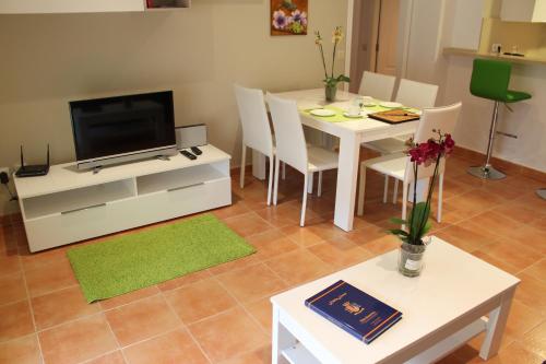 a living room with a white table and a television at Apartment Las Dunas in Jávea