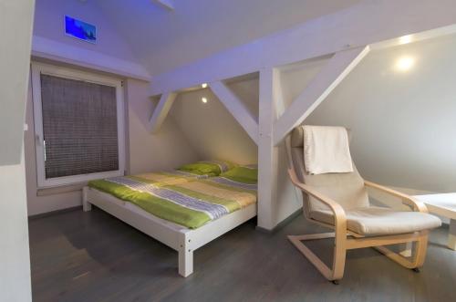 a small bedroom with a bed and a chair at Spreeperle in Lübbenau