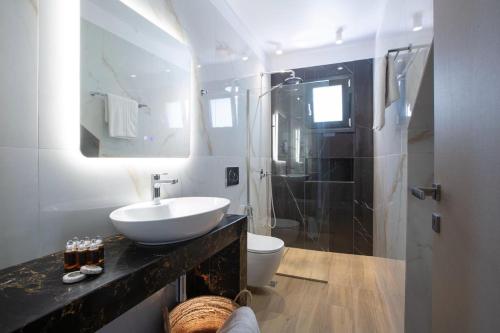 a bathroom with a sink and a toilet and a mirror at Amalfi Twins Villa in Nydri