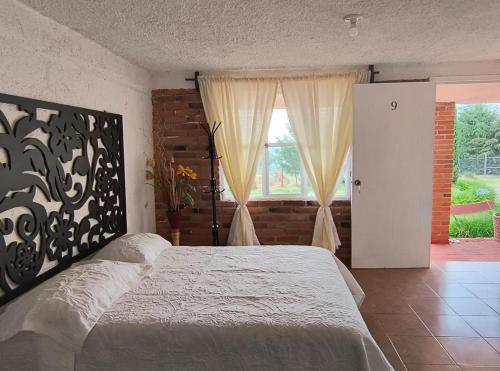 a bedroom with a large bed and a window at Centro Ecoturístico Rancho Buenavista in Nanacamilpa