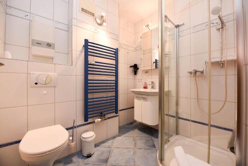 a bathroom with a toilet and a shower and a sink at Haus "Luv und Lee" Appartement LUV34 in Döse