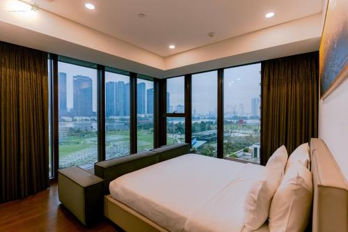 a bedroom with a bed and large windows at ChiHome Metropole The Opera Residence Luxury in Ho Chi Minh City