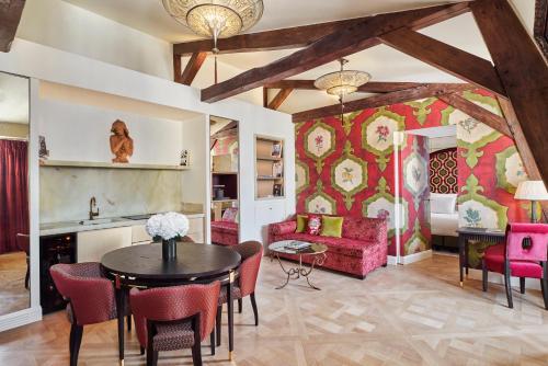 a living room with a table and chairs and a couch at Maison Barrière Vendôme in Paris