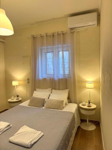 a bedroom with a bed and two lamps and a window at Spiros apartment - Loggos, Paxos in Longós