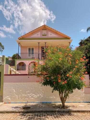 a house with a tree in front of it at Casa Om Shanti in Passa Quatro