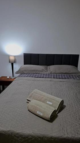 a bed with two towels on top of it at Confortável & Bem Localizado! in Campo Grande