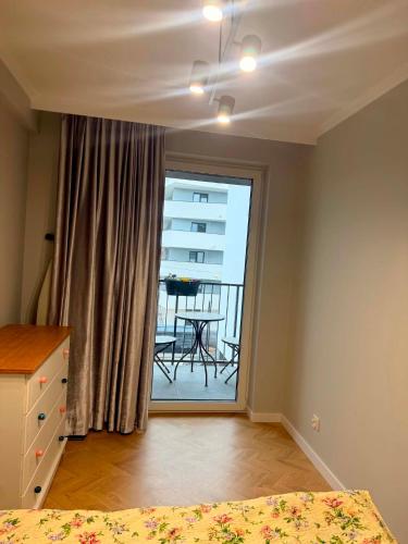 a bedroom with a bed and a window with a table at Apartament Ablewicza VIP in Tarnów