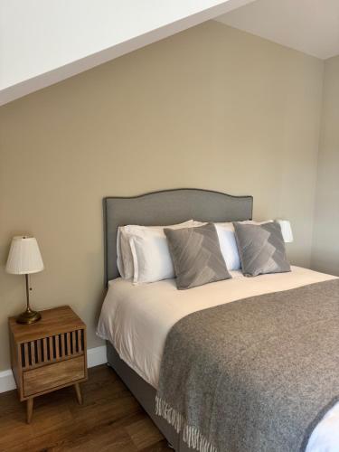 a bedroom with a bed and a table with a lamp at Studio 7 in Dungannon