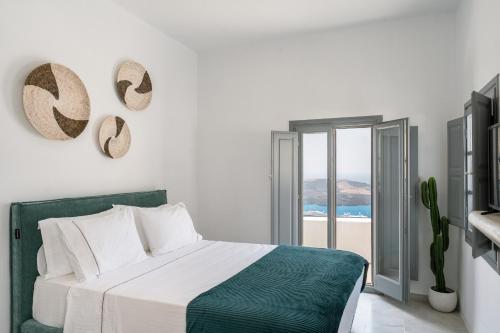 a bedroom with a bed and a view of the ocean at Anemos Fira Caldera View in Fira