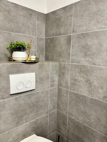 a bathroom with a toilet and a tile wall at Enjoy-Zimmer in Altenahr