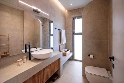 a bathroom with a sink and a toilet at Anemolia Villas in Karpathos