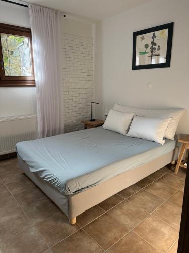 a bed in a white room with at M Villa Pelion in Tsagarada