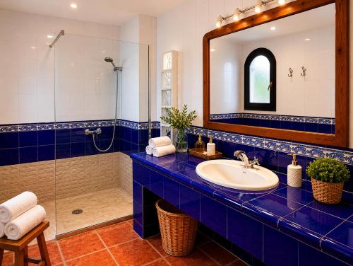 a blue bathroom with a sink and a shower at Le Mirage in Cambrils